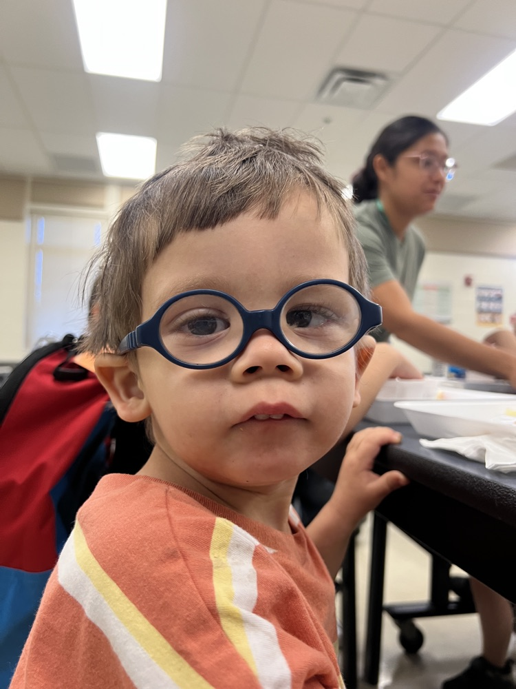 student with glasses sitting at breakfast