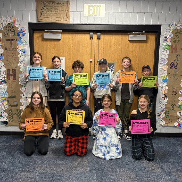 Students holding certificates in front of banners