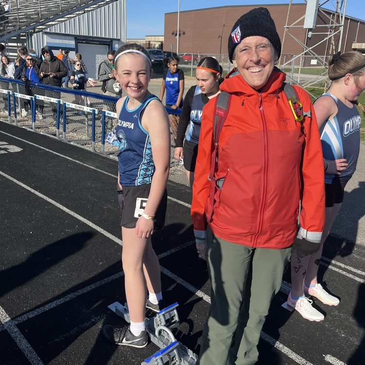 athlete and volunteer standing at starting blocks