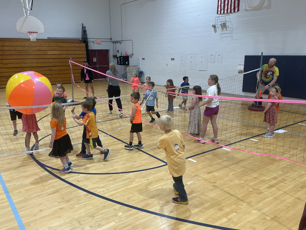 Kindergarten trying their best at beach volleyball.