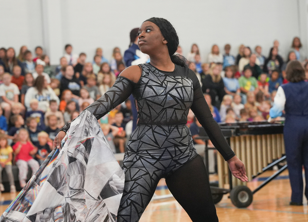 Student dancing with a flag in a school gymn