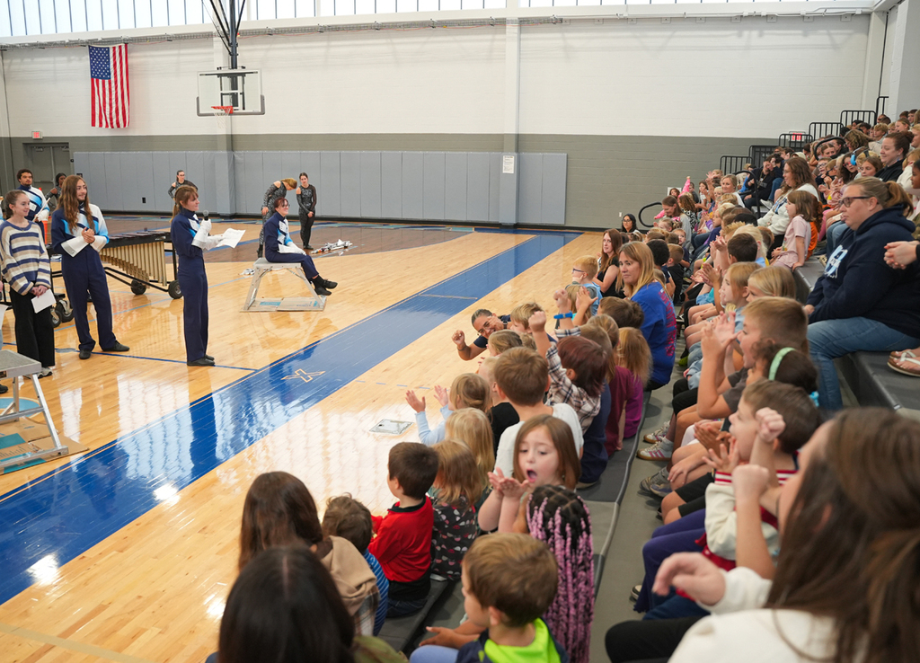 Students enjoying a musical performance in a school gym