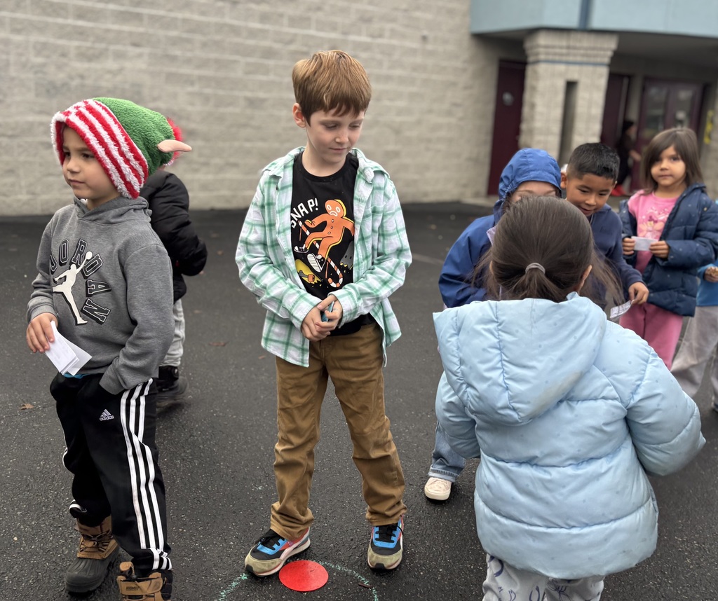 Kindergarten students demonstrating safe and responsible by waiting in line to purchase popcorn.