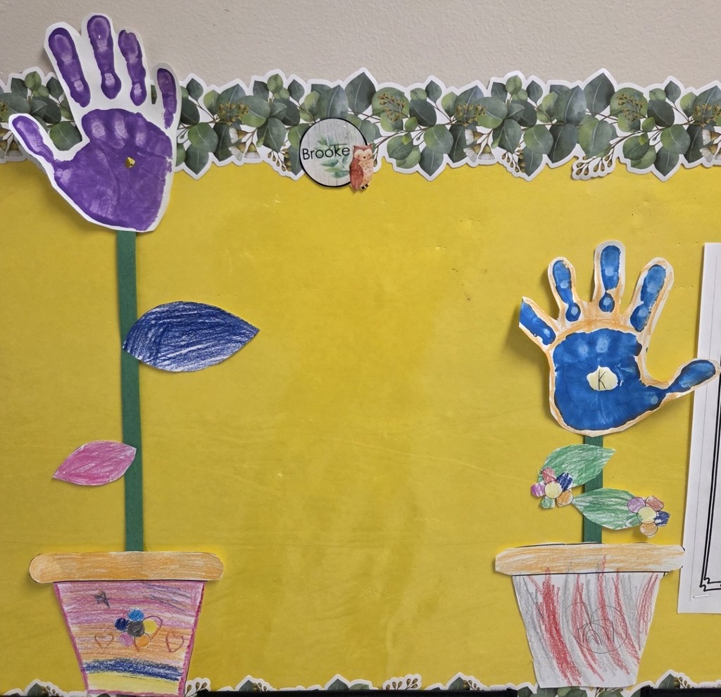 Decorated paper flower pots with student's hands as the flower.