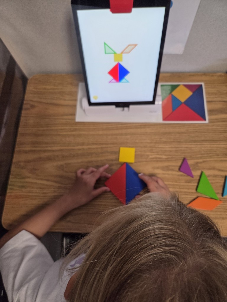 A student working on an OSMO tangram puzzle shaped like a rabbit.