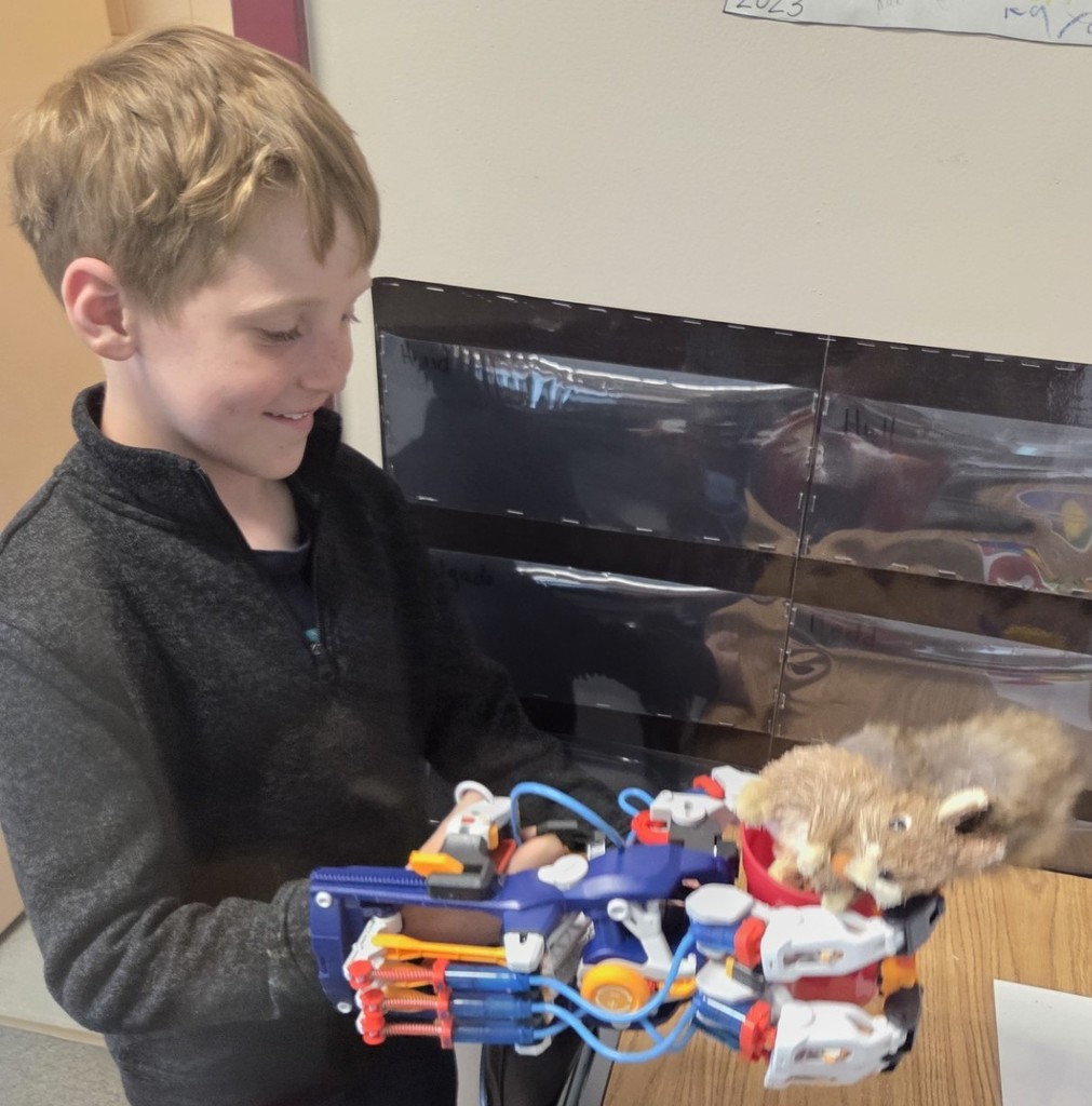 A North Elementary student shows his skills by using the Mega Cyborg Hand to put the toy squirrel in the cup and pick the cup up with the squirrel in it.