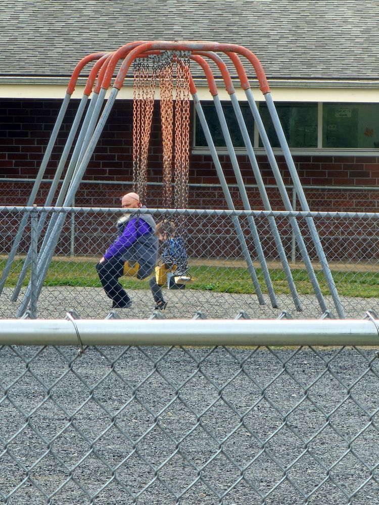 Mr. Markuson and student on swings