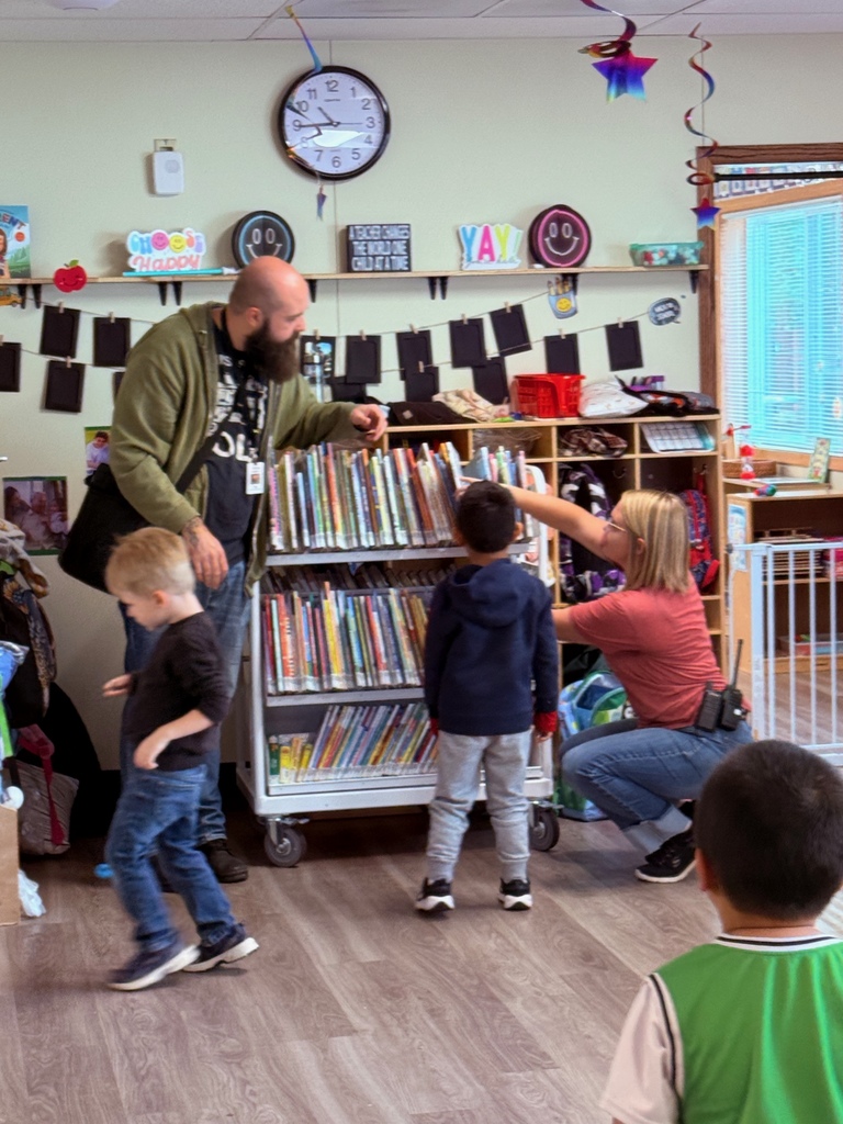 students looking at books with librarian