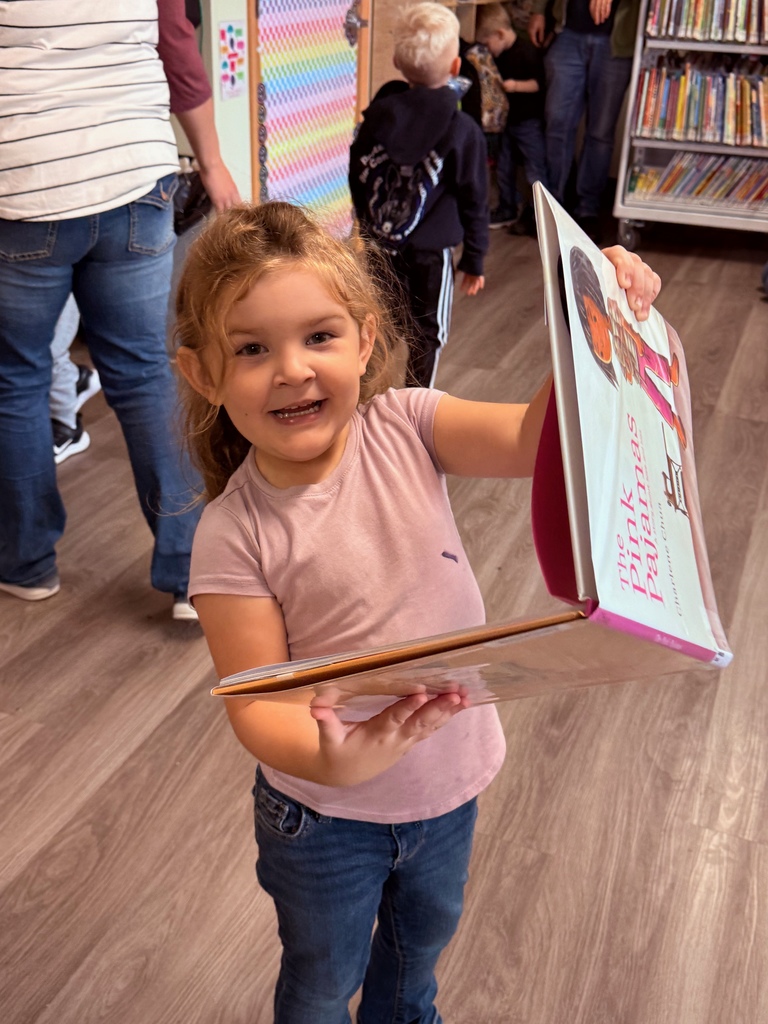 Preschool student checking out a book