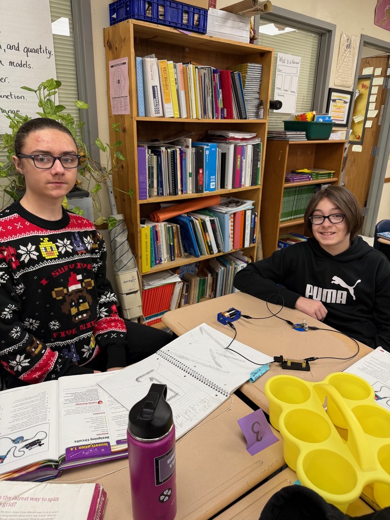 Middle school students posing with their experiment