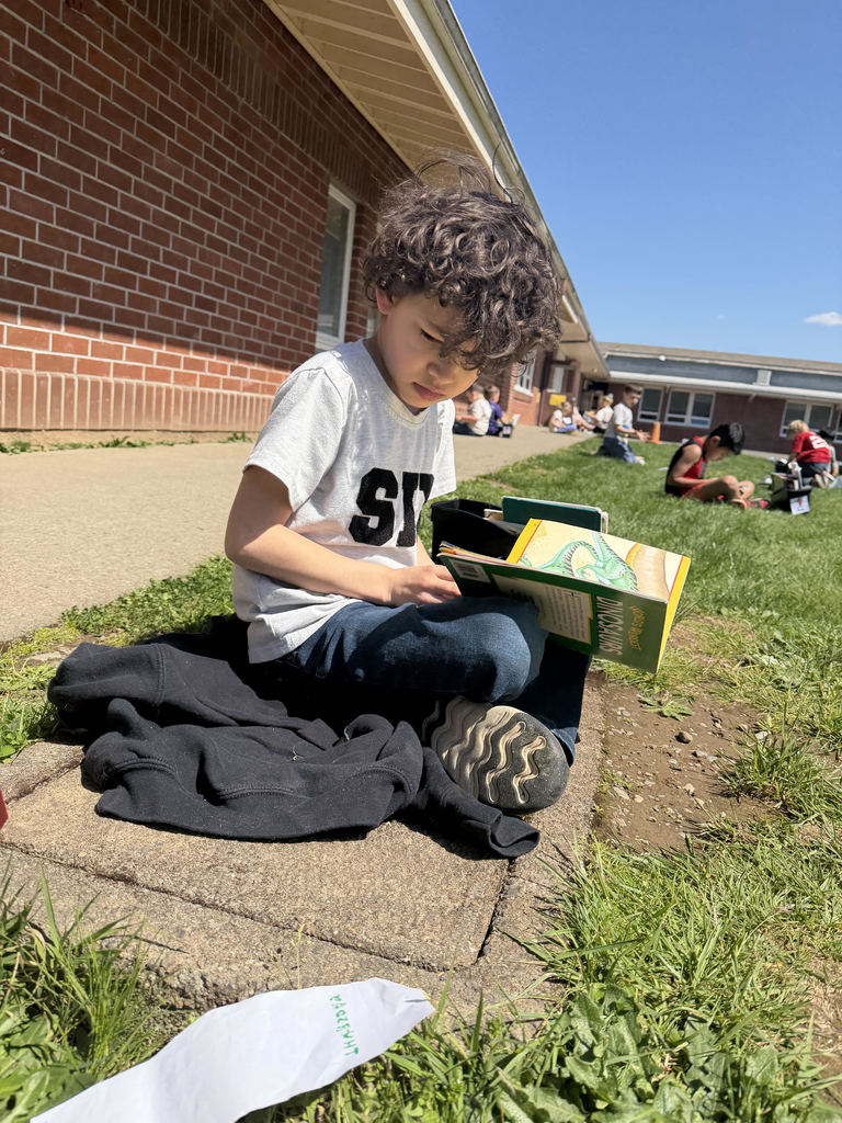 First grade student reading in the sun