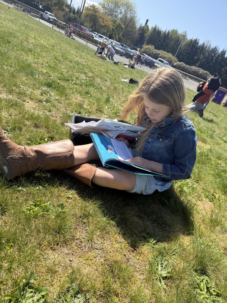 First grade student reading in the sun