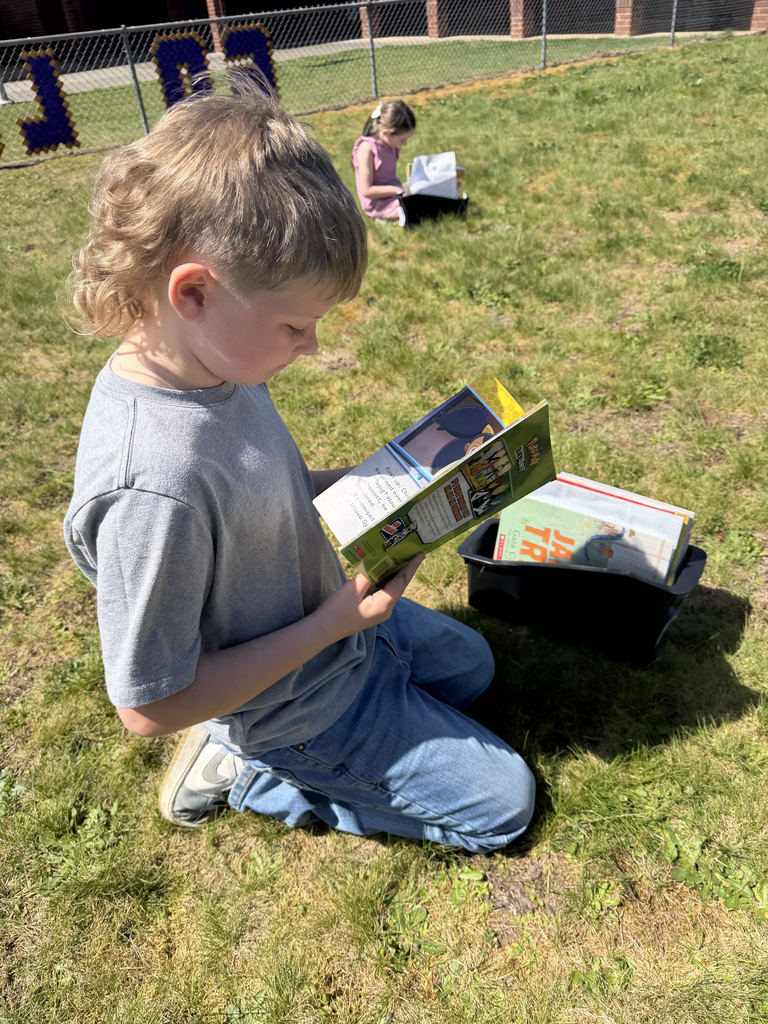 First grade student reading in the sun