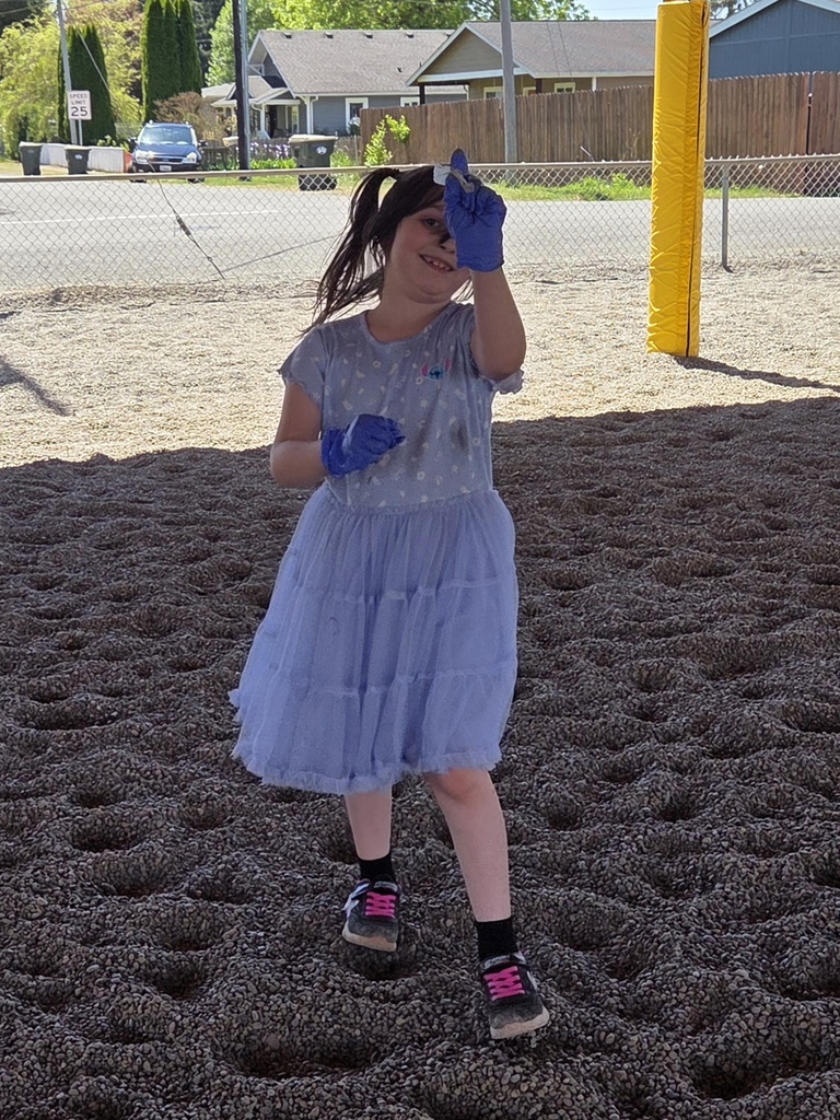 student showing a piece of trash from the playground