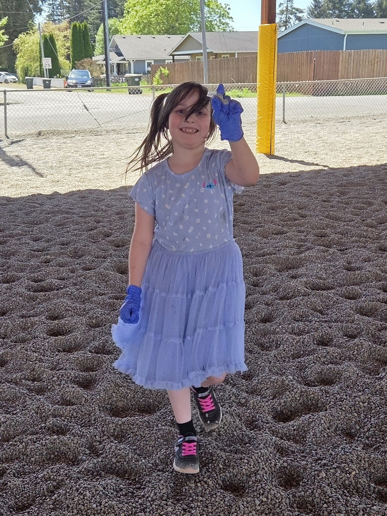 student showing a piece of trash from the playground