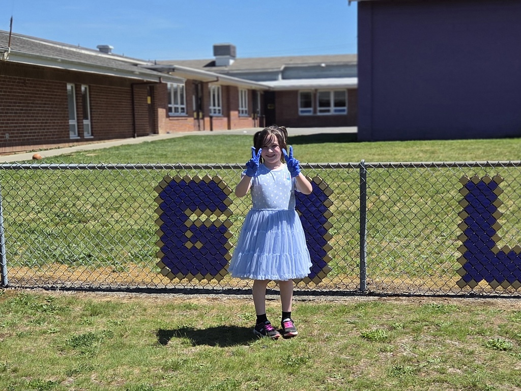 Student that has been picking up trash giving the peace sign
