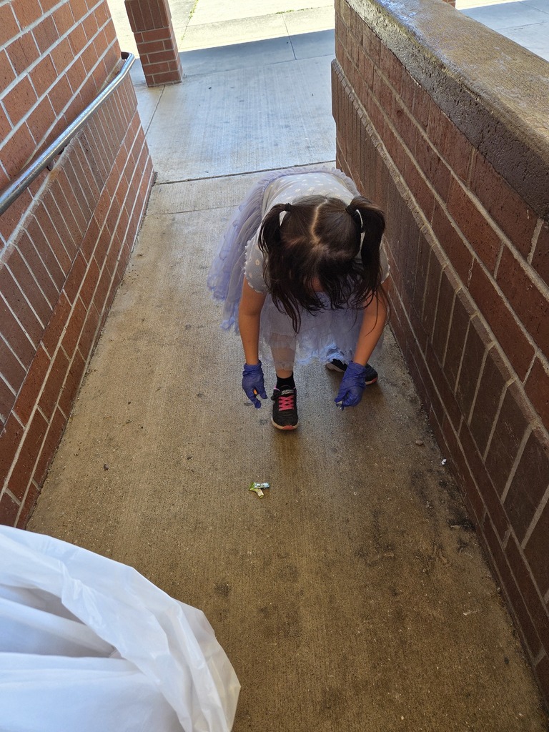 student picking up trash in a breeze way