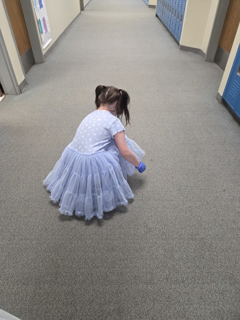 student picking up trash in the hallway