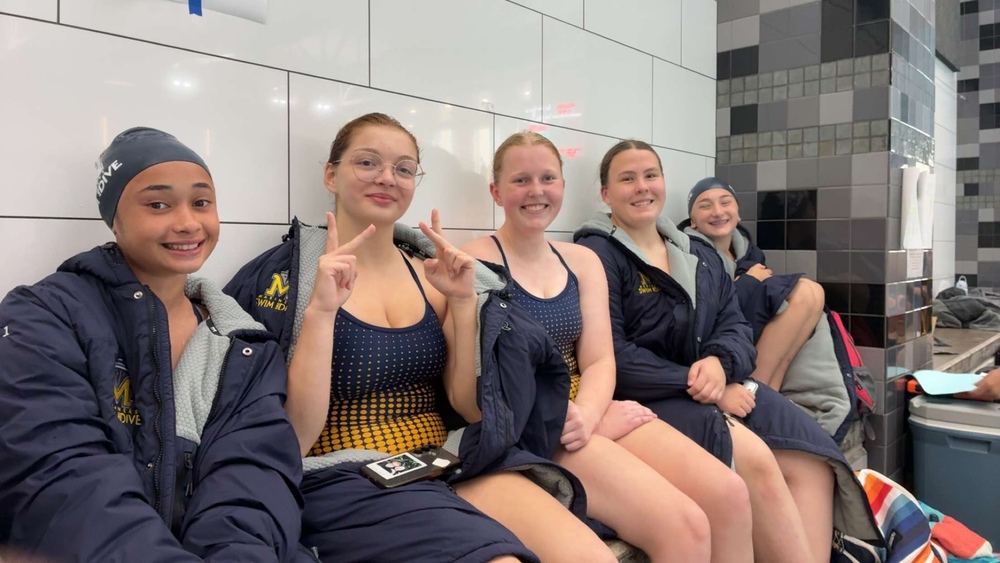 Onekama senior and co-op athlete Faith Fessenden (second from left) poses with the Manistee swim team.