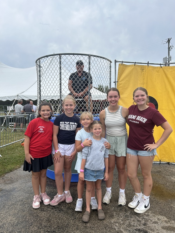 Superintendent Dan Mesyar smiles from the dunk tank for a photo with current Onekama students.