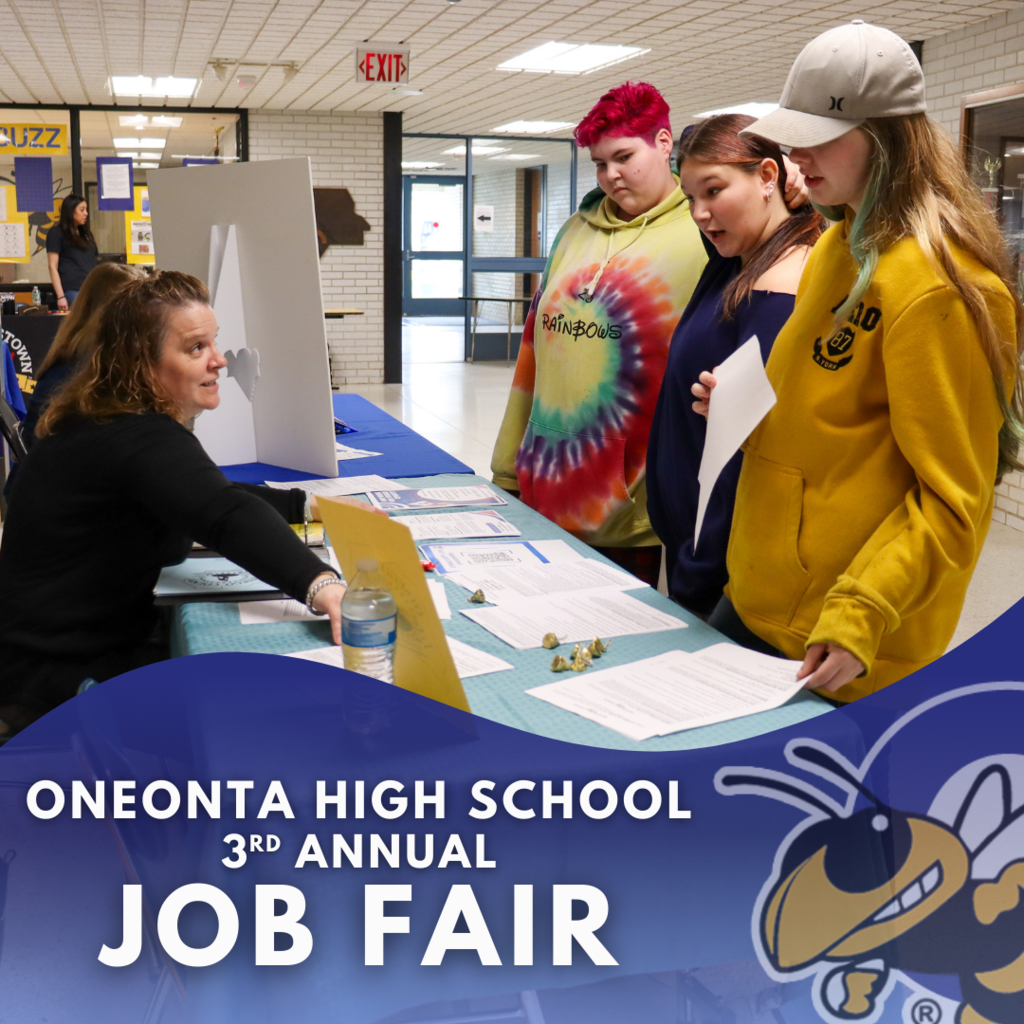 3 students standing in front of a table talking to a woman behind it in a school hallway.