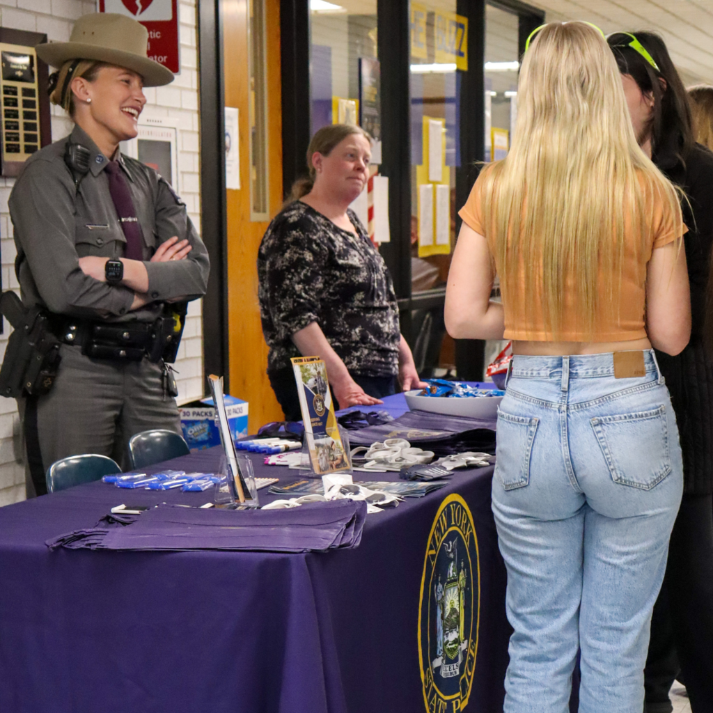 two students talking to a New York State Trooper.