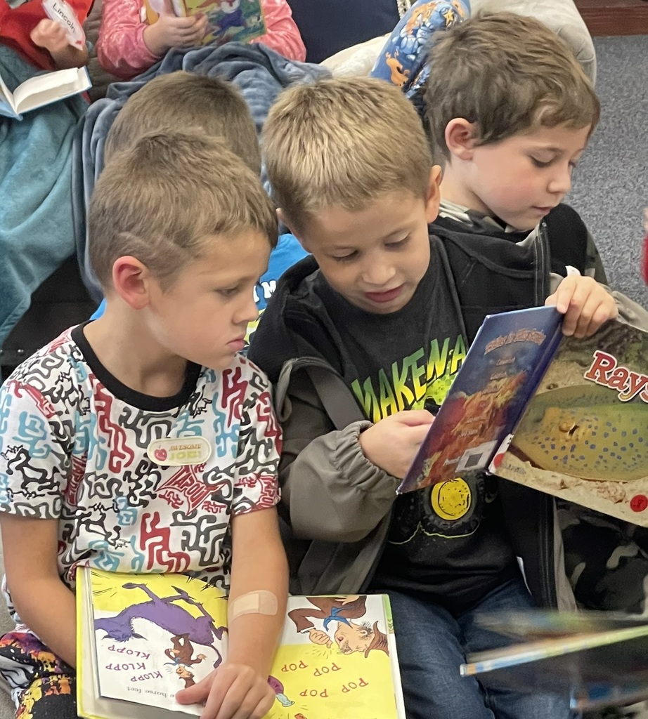 two boys looking at a book