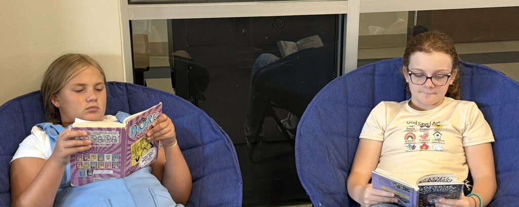 Student sitting in a chair reading a book