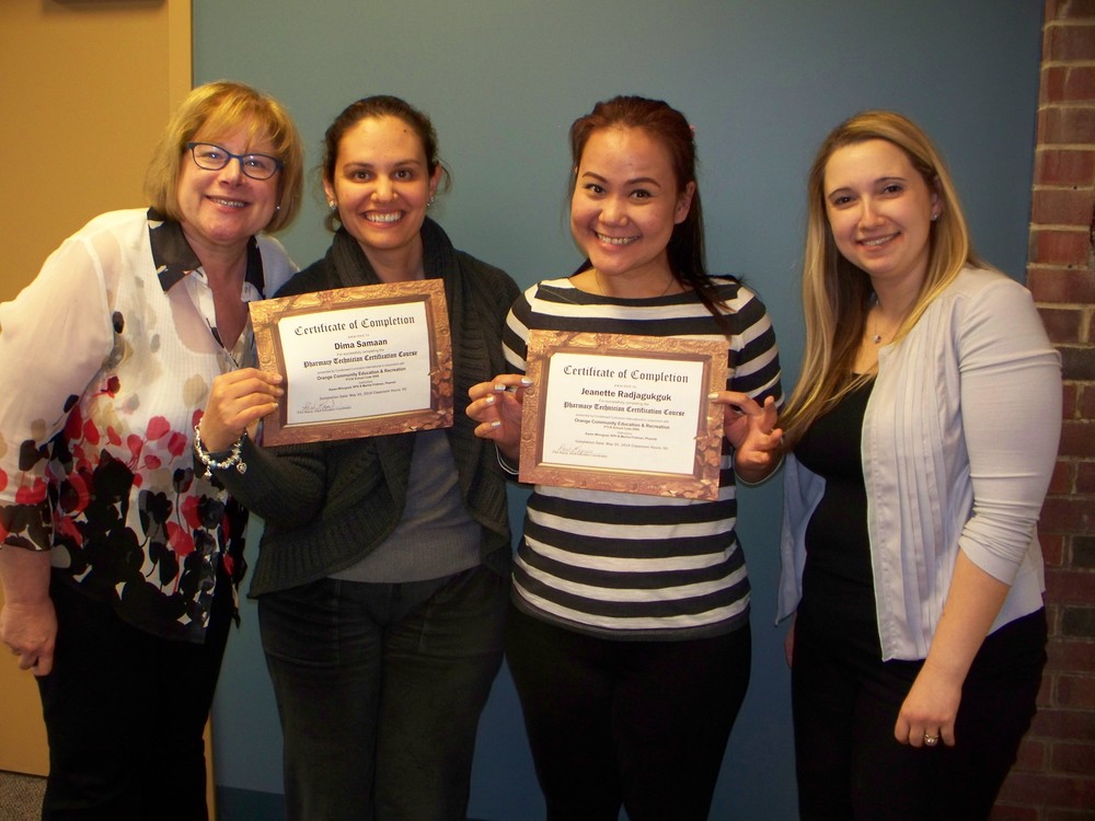 Four women smiling at the camera and holding certificates for completing a class