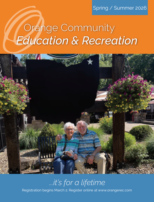 A couple sitting on a bench and smiling at the camera on the cover of the Spring/Summer recreation guide