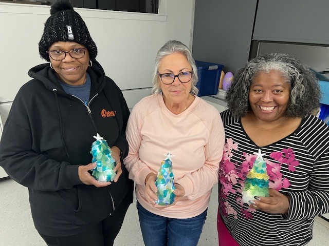 A group of women holding sea glass trees that light up