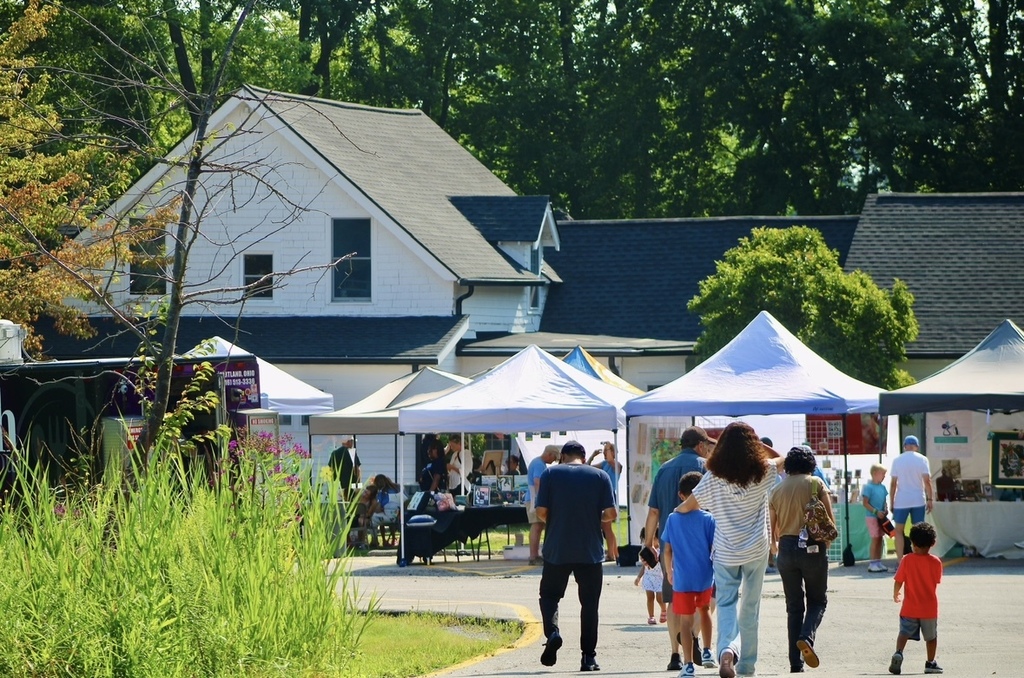 The Orange Community Art Fest with white tents and event goers walking around the event