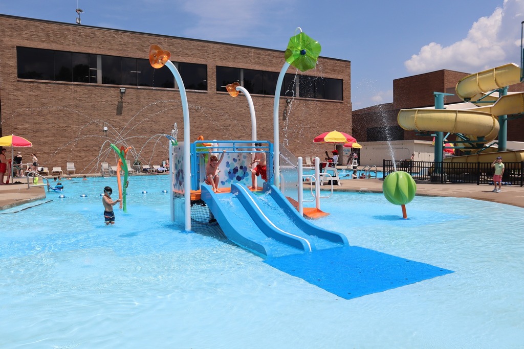 The Orange Outdoor Pool with the water feature and slide in the background