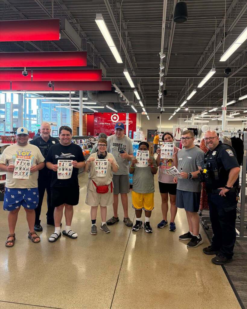 Group of participants in Target, holding safety papers and smiling at the camera