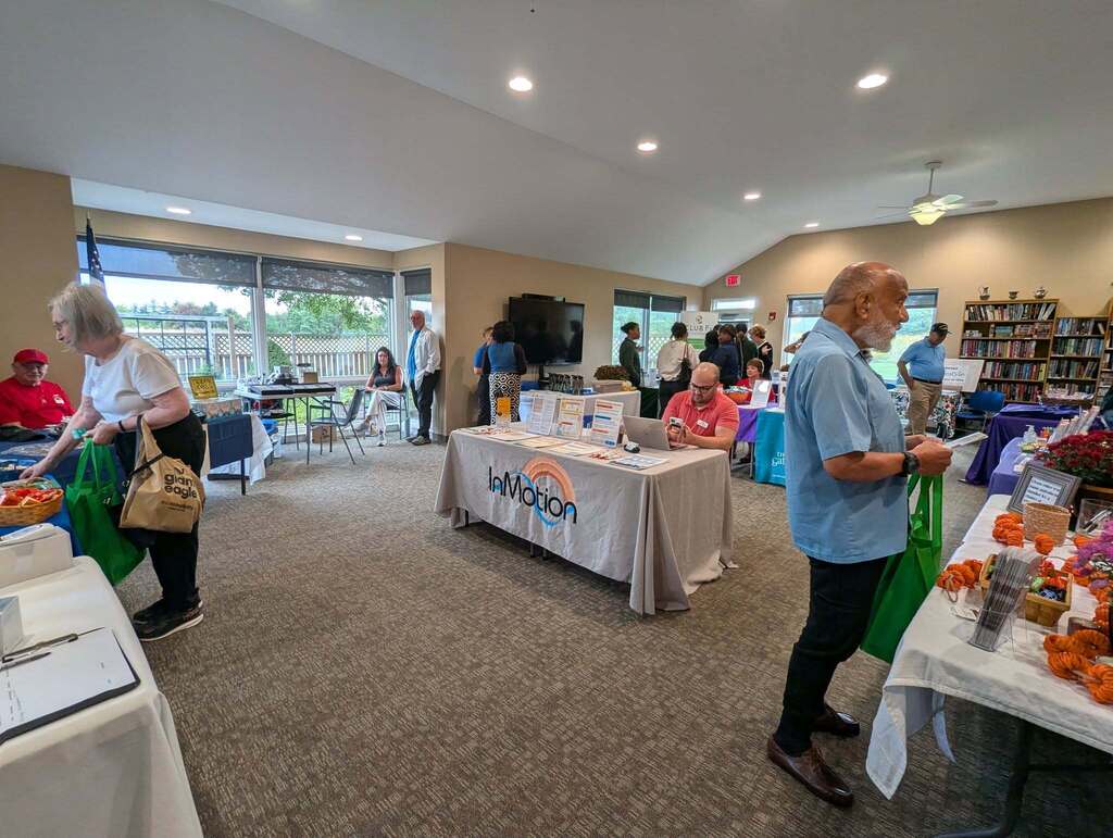 Health tables set up at the Orange Senior Center with participants talking to vendors at the tables