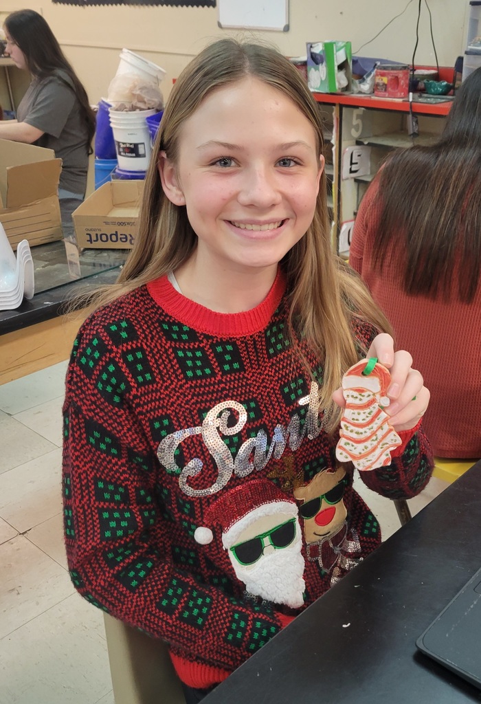 8th grade student posing with her ornament.