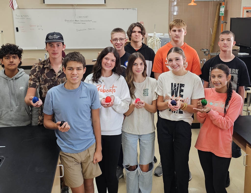 group of students holding colored eggs