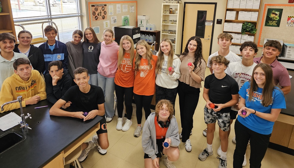 large group of students holding colored eggs