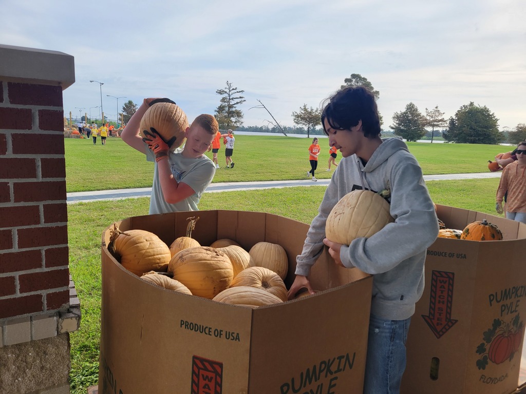 A photo of students setting up for orangetober fest.