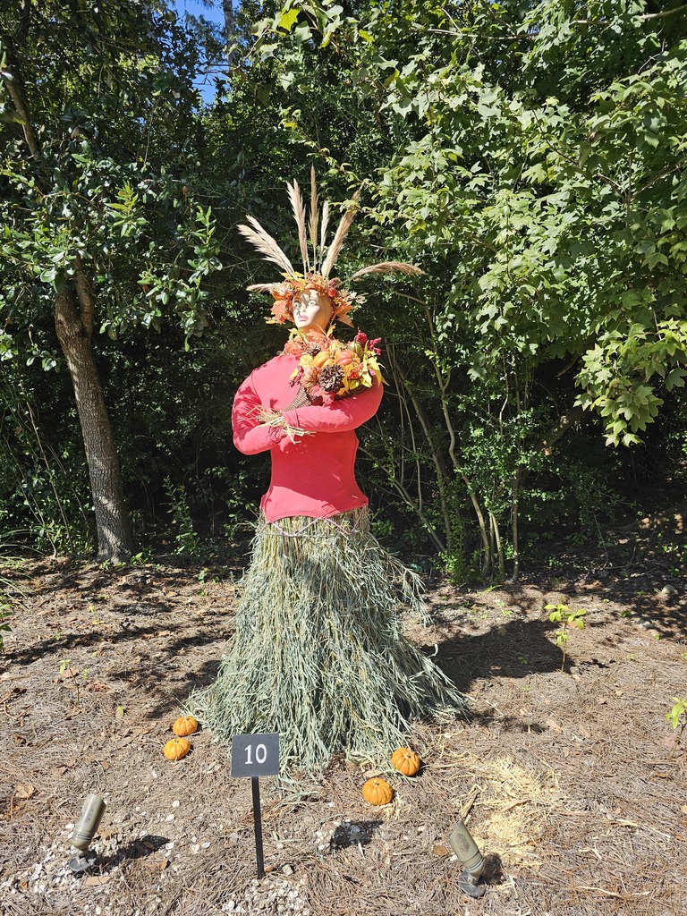 scarecrow crafted from straw with a red shirt and wheat headdress