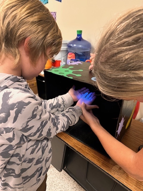 child with hands under a blue light