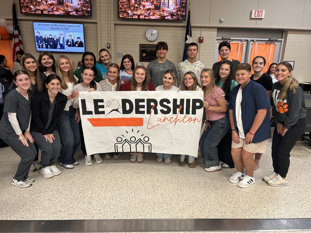students around the leadership luncheon sign