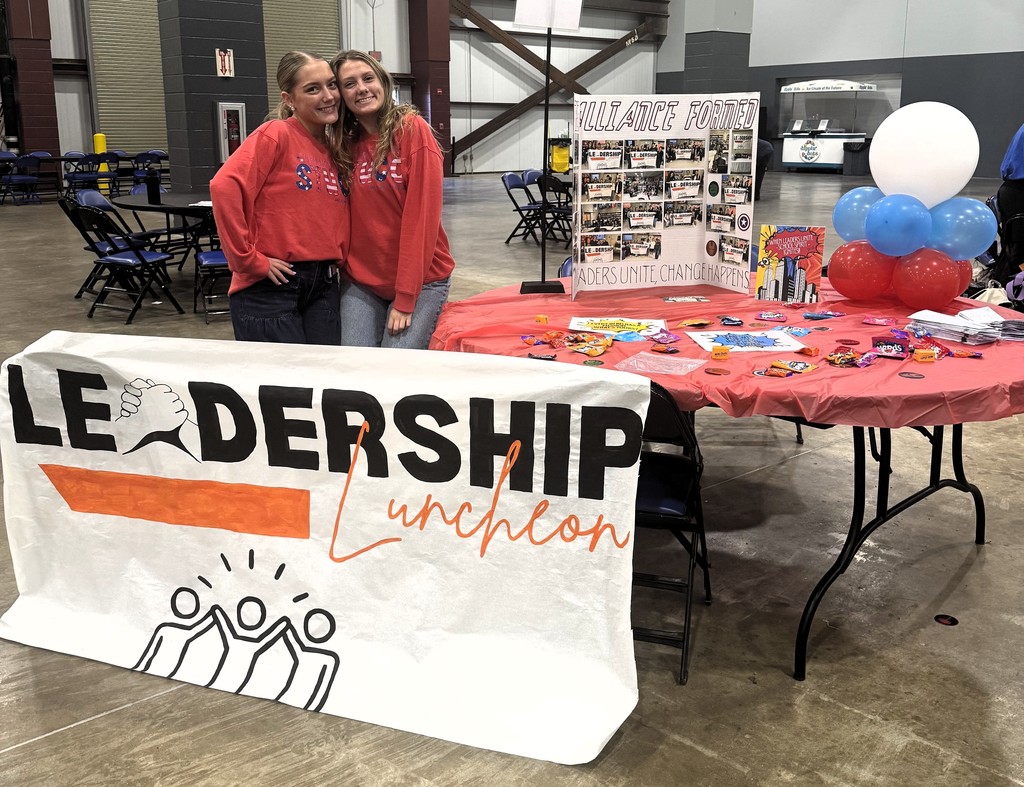 two students with leadership luncheon poster