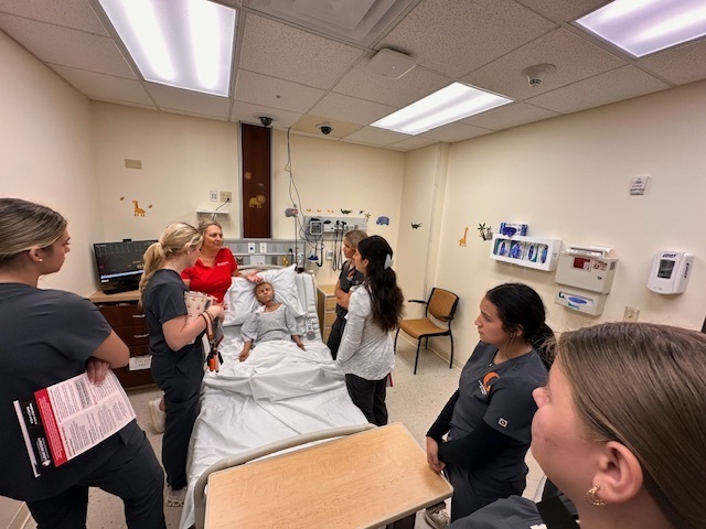 students and instructor around a mannequin