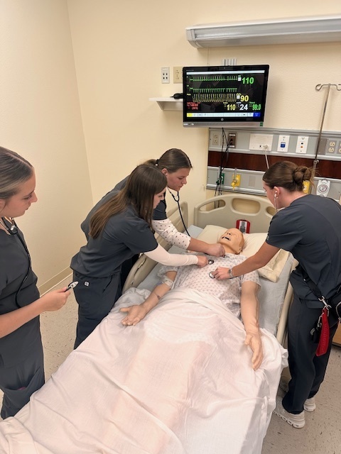 students practicing on a mannequin