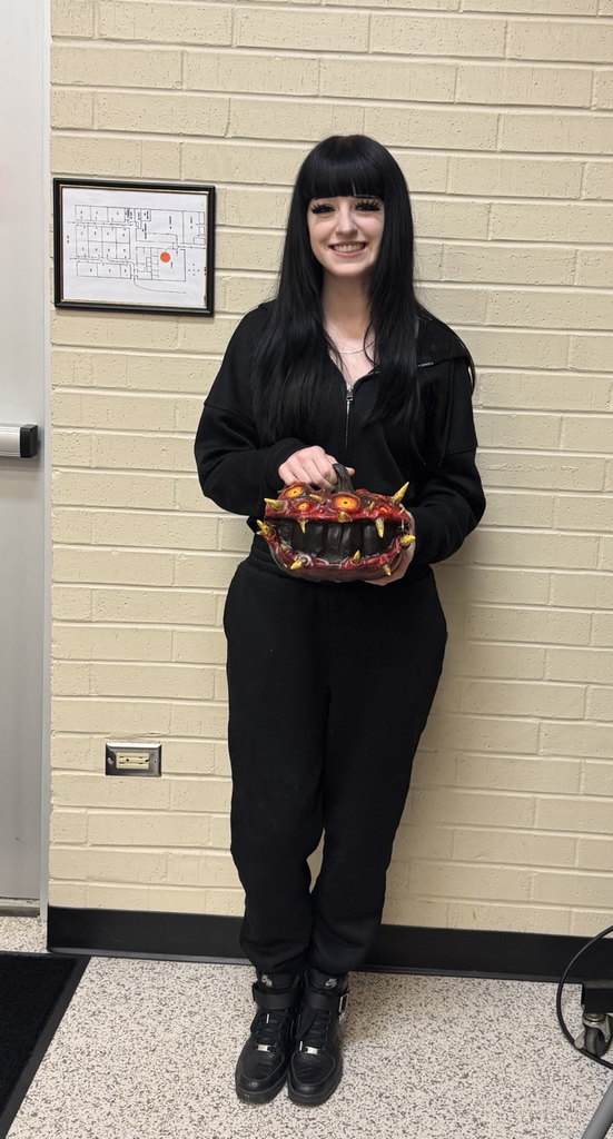 student holding decorated pumpkin