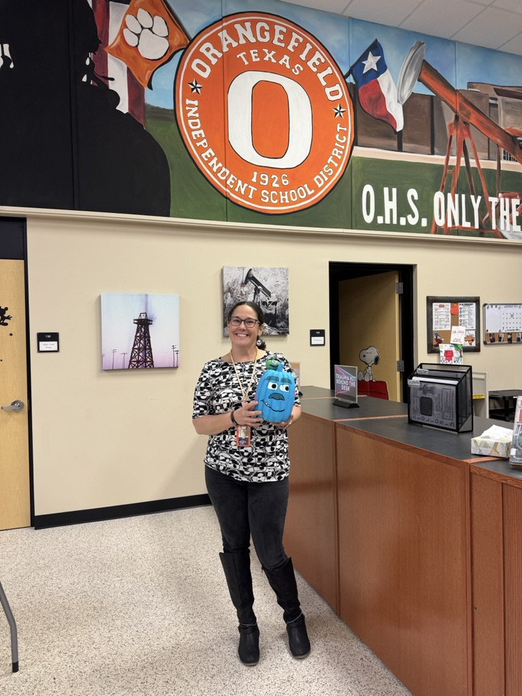 teacher holding decorated pumpkin
