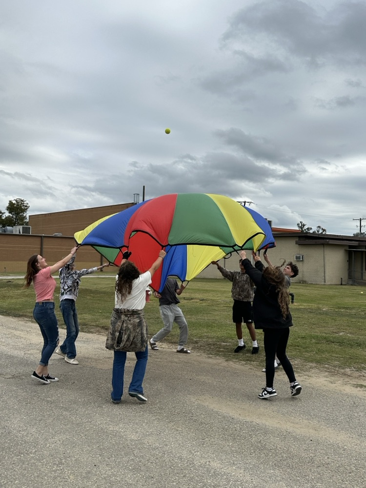 students holding a colorful parachute