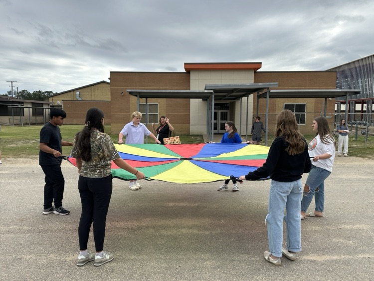students holding a colorful parachute