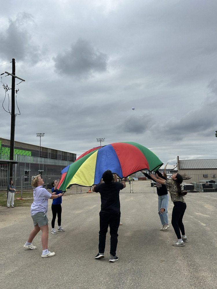 students holding a colorful parachute
